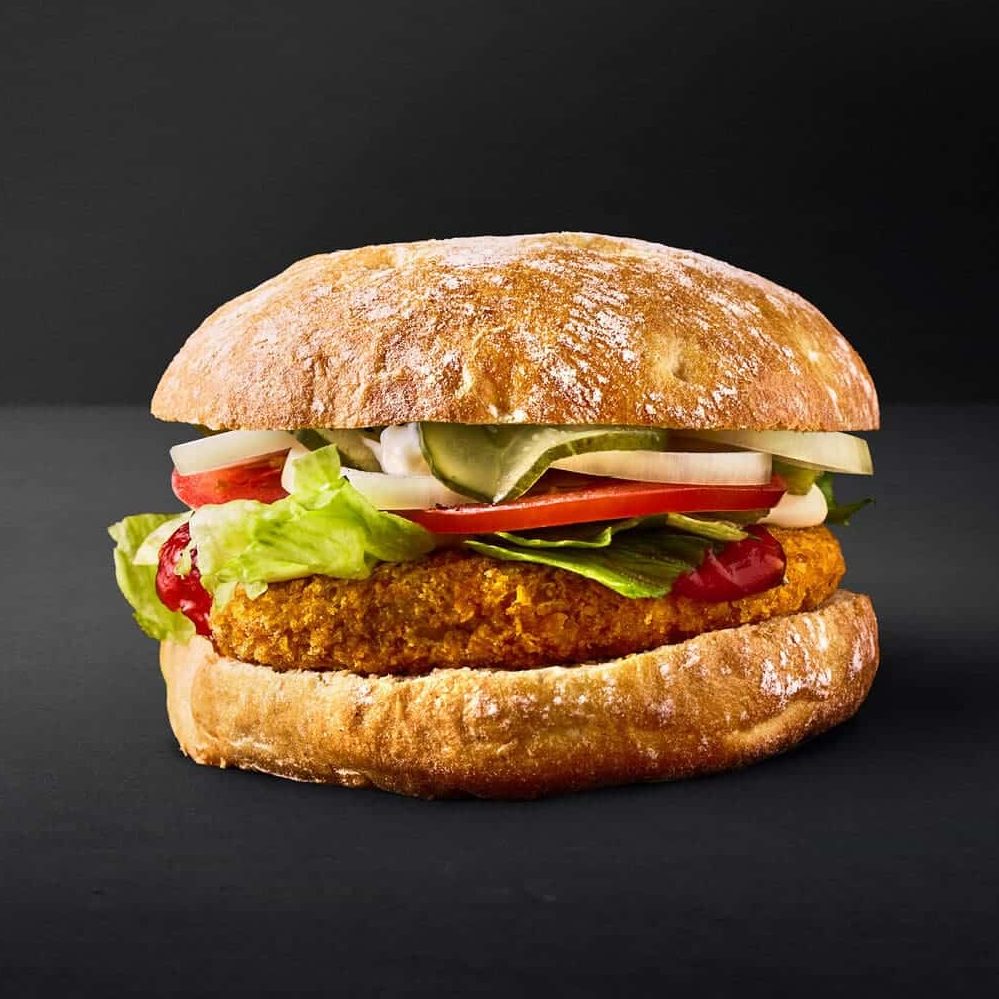 En crispy plantebaseret burger med en lækker bøf, serveret i en blød bolle med friske grøntsager
